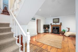 a living room with a staircase and a fireplace at The Old Bakehouse - Group Getaway in Llandysul