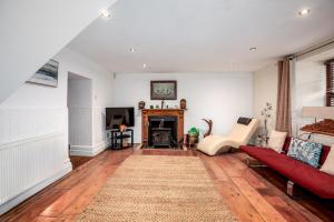 a living room with a red couch and a fireplace at The Old Bakehouse - Group Getaway in Llandysul