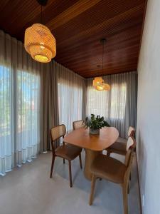 a dining room with a wooden table and chairs at Recanto Gamboa in Garopaba
