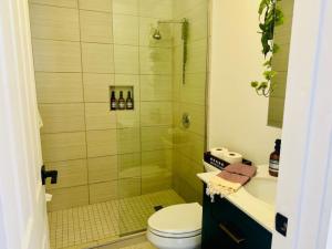 a bathroom with a shower and a toilet and a sink at Jungle House Luxury Homes - Columbus Downtown Short North - Steps to Convention Center & Nationwide Arena - Sleeps up to 8 - Free Parking - Over 5,800 Five Stars in Columbus