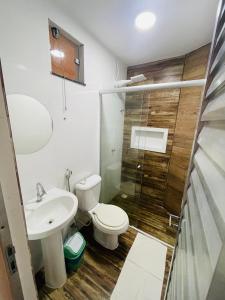 a bathroom with a toilet and a sink and a shower at Isadora Pousada in Salinópolis