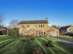 an old stone house with a large yard at Orchard House in Leyburn