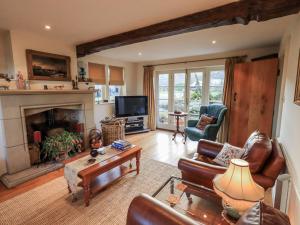a living room with a couch and a fireplace at Orchard House in Leyburn