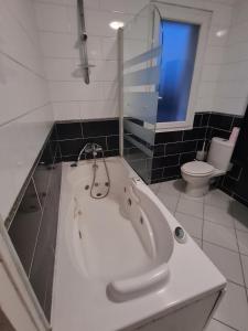 El baño incluye bañera blanca y aseo. en Large house near Mérignac Airport, en Mérignac 15 fotos más