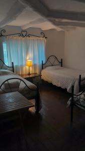 a bedroom with two beds and a window with a lamp at Casa Corazao in Urubamba