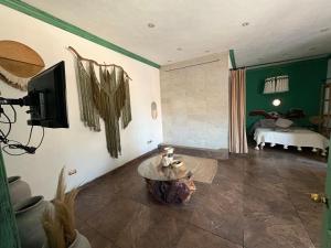 a living room with a table and a bedroom at Boho luz terrace in San Miguel de Allende