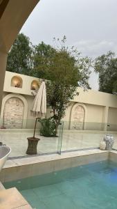 an outdoor swimming pool with an umbrella and an umbrella at نزل فاخر in Taif