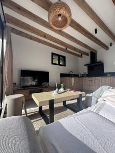 un soggiorno con un tavolo e una tv di Le refuge de César a Pouzac