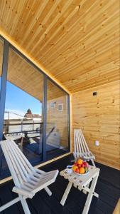 two chairs and a table with fruit on a porch at Aiwa Eco Hotel in Karakol +3 photos