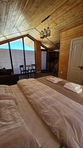 a large bed in a room with a table at Aiwa Eco Hotel in Karakol