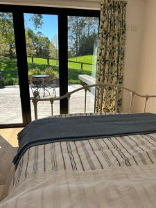 a bed in a room with a view of a patio at The woolshed - Oruanui in Oruanui