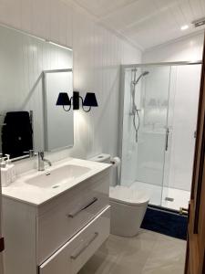 a white bathroom with a sink and a shower at The woolshed - Oruanui in Oruanui