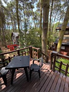 a picnic table and chairs on a wooden deck at Ayrampo in Mar de las Pampas