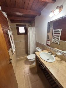 a bathroom with a sink and a toilet and a mirror at Ayrampo in Mar de las Pampas
