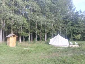 Grande tente au pied du Vercors في Saint-André-en-Royans: خيمة بيضاء مع كرسيين في الميدان