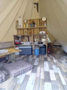 Grande tente au pied du Vercors في Saint-André-en-Royans: خيمة مع طاولة ورفوف في غرفة