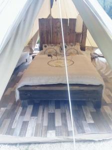 Grande tente au pied du Vercors في Saint-André-en-Royans: سرير داخل خيمة مع مرتبة