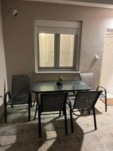 Una mesa y sillas en una habitación con ventana. en Nest of paradise 2, en Tríkala