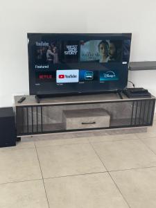 un téléviseur à écran plat posé sur un centre de divertissement dans l'établissement Shine house, à Somerset West