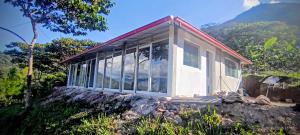 Ein kleines Haus auf einem Felsen mit Bergen im Hintergrund in der Unterkunft Hacienda & Reserva Monterrico in Romilda