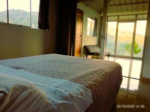 a bedroom with a bed and a large window at Hacienda & Reserva Monterrico in Romilda