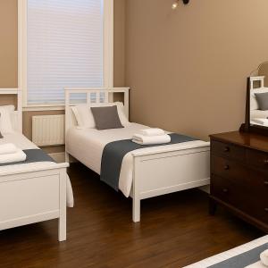 a bedroom with two white beds and a window at High Living in Carlisle
