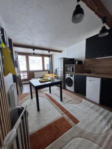 a kitchen with a table in the middle of a room at Appartements pied des pistes - Résidence Mongie - Tourmalet in La Mongie