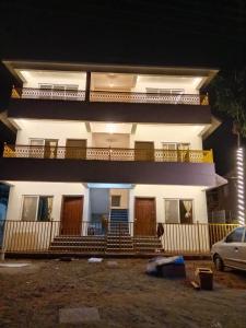 a house with a car parked in front of it at Hare Krishna Beach Resort in Srīvardhan