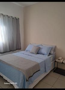 Enjoy Canastra في ديلفينوبوليس: غرفة نوم بسرير وملاءات زرقاء ونافذة