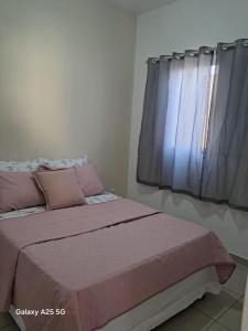 Enjoy Canastra في ديلفينوبوليس: غرفة نوم مع سرير وردي مع نافذة