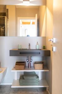un baño con lavabo y espejo en La casa tra gli ulivi, en Génova 31 fotos más