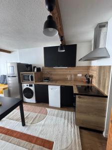 a kitchen with black and wooden counters and appliances at Appartements pied des pistes - Résidence Mongie - Tourmalet in La Mongie
