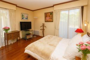 a bedroom with a white bed and a television at Appartement Premium 100 m2 avec Jardin Privé Plage et Centre à 400 m in Deauville