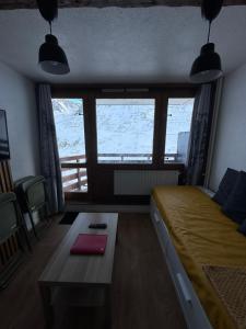 a bedroom with a bed and a table and a window at Appartements pied des pistes - Résidence Mongie - Tourmalet in La Mongie