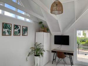 a white room with a desk and a tv on a wall at Imhoff's Gift Sweet Escape in Imhoffʼs Gift +19 photos