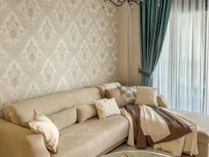 a living room with a couch with pillows on it at Апартаменты Qoople Triumph 17 рядом с пляжем Клеопатры in Alanya +14 photos