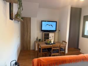 Un comedor con una mesa y un televisor. en Casa Rural Antikaria, en Antequera