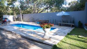 a swimming pool with a bench and a vase with flowers at Casa Bosque da Serra in Crato