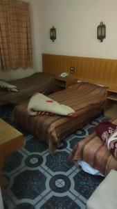 卢克索New mostafa hotel的酒店客房,配有两张床,铺有地毯 更多5张照片