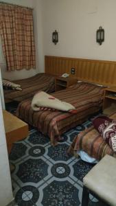 卢克索New mostafa hotel的酒店客房,配有两张床,铺有地毯