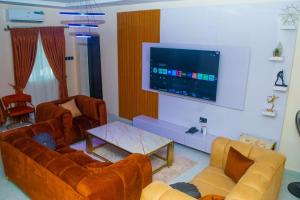 a living room with couches and a flat screen tv at Gpark Luxury Homes And Apartments in Sagamu