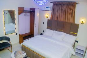 a bedroom with a large bed and a chair at Gpark Luxury Homes And Apartments in Sagamu +5 photos