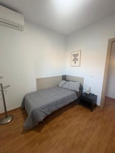 Un dormitorio con una cama y suelo de madera. en Casa Rural Antikaria, en Antequera