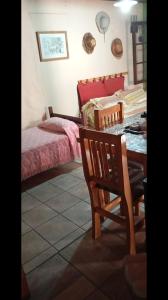 een slaapkamer met een bed en een tafel met een stoel bij Casa de Olga in Tandil