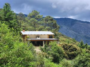 a house on the side of a mountain at Cabañas La Moneda in Rancho La Carolina