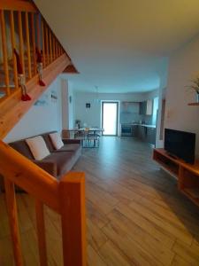 Una sala de estar con un sofá y una escalera. en Appartamento Morettina con terrazzo, en Levico Terme