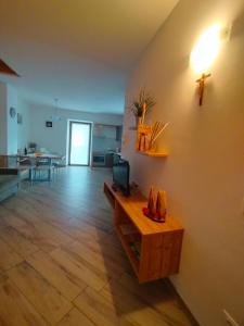 Una sala de estar con una mesa y una cruz en la pared. en Appartamento Morettina con terrazzo, en Levico Terme