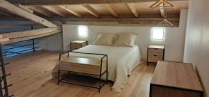 a bedroom with a bed with two night stands and a table at GITE La GRANGE in Launac