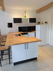 a kitchen with white cabinets and a wooden counter top at GITE La GRANGE in Launac