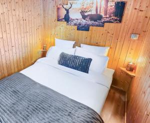 a bedroom with a white bed and a picture of a deer at Chalet Cocoon en lisière de forêt, avec grande terrasse, et vue 'waouh' in Allevard +67 photos